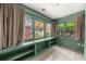 Bright sunroom featuring built-in shelves, tile floors, and multiple windows showcasing the yard at 220 Sisson Ne Ave, Atlanta, GA 30317