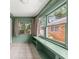Bright sunroom featuring built-in shelves, tile floors, and multiple windows showcasing the yard at 220 Sisson Ne Ave, Atlanta, GA 30317