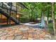 Charming backyard patio with flagstone, mature trees, and a shaded seating area at 230 Leaf Court, Alpharetta, GA 30005