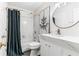 Bathroom featuring a shower-tub combo, round mirror, modern vanity, and stylish decor at 230 Leaf Court, Alpharetta, GA 30005
