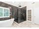 This bathroom features a soaking tub, a glass shower, and white marble floors at 230 Leaf Court, Alpharetta, GA 30005
