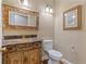 This well-decorated powder room features a golden faucet and a vanity adorned with hand-painted flowers at 230 Leaf Court, Alpharetta, GA 30005