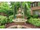 A tiered fountain surrounded by lush landscaping adds elegance to the home's exterior at 230 Leaf Court, Alpharetta, GA 30005