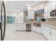 Bright kitchen features white cabinets, stainless steel appliances, and granite countertops at 230 Leaf Court, Alpharetta, GA 30005