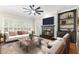 Cozy living room features a fireplace, built-in shelves, plantation shutters, and ample seating at 230 Leaf Court, Alpharetta, GA 30005