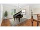 This music room is spacious and bright, with a dark, elegant grand piano and hardwood floors at 230 Leaf Court, Alpharetta, GA 30005