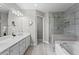 Bright bathroom with double vanity, soaking tub, and glass-enclosed shower at 4910 Longcourt Se Trce # 13, Atlanta, GA 30339