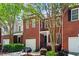 Charming brick townhome with mature landscaping, attached garages, and tree-lined street at 4910 Longcourt Se Trce # 13, Atlanta, GA 30339