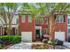Beautiful brick townhome featuring an attached garage and professionally landscaped front yard at 4910 Longcourt Se Trce # 13, Atlanta, GA 30339