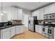 Modern kitchen features white cabinetry, granite countertops, and stainless steel appliances at 4910 Longcourt Se Trce # 13, Atlanta, GA 30339