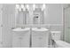 Bathroom featuring double sinks with framed mirrors and bright white cabinets at 516 Broad Head Pt, Suwanee, GA 30024