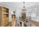 Charming dining room with hardwood floors, a modern chandelier, and views into the kitchen at 516 Broad Head Pt, Suwanee, GA 30024