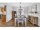 Elegant dining room with a modern chandelier, hardwood floors, and white wainscoting at 516 Broad Head Pt, Suwanee, GA 30024