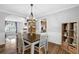 Bright dining area with stylish lighting, hardwood floors, and neutral decor, adjacent to the living room at 516 Broad Head Pt, Suwanee, GA 30024