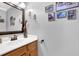 Elegant powder room featuring wooden vanity, modern fixtures, and decorative wall art at 516 Broad Head Pt, Suwanee, GA 30024