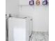 Efficient laundry room with white washer and dryer set and overhead storage at 1285 Avon Sw Ave, Atlanta, GA 30310