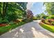 Long concrete driveway lined with manicured landscaping and mature trees at 2695 Rangewood Ne Dr, Atlanta, GA 30345