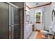 Bright bathroom with a glass-enclosed shower and vintage-style fixtures at 7720 Milam Rd, Winston, GA 30187
