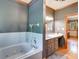 Bathtub and vanity combination with unique tiling and wood accents at 7720 Milam Rd, Winston, GA 30187