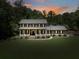 Charming two-story home with a covered front porch and a lush green lawn surrounded by mature trees at 7720 Milam Rd, Winston, GA 30187