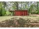 Outdoor red storage shed in a yard with trees, perfect for storing equipment at 7720 Milam Rd, Winston, GA 30187