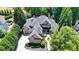 Luxury brick home with mature trees, manicured lawn, and welcoming circular driveway at 8525 Saint Marlo Fairway Way, Duluth, GA 30097