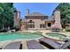 Resort-style backyard featuring a pool, hot tub, and outdoor lounge area with lush greenery at 8525 Saint Marlo Fairway Way, Duluth, GA 30097
