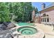 Gorgeous backyard featuring a pool, hot tub, patio, and lush landscaping, creating a serene outdoor oasis at 8525 Saint Marlo Fairway Way, Duluth, GA 30097