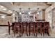 View of the basement bar area with cabinets, stone walls, and a countertop, highlighted by pendant lighting at 8525 Saint Marlo Fairway Way, Duluth, GA 30097