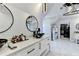 A luxurious bathroom featuring dual sinks, a frameless glass shower, designer lighting, and a walk-in closet in view at 8525 Saint Marlo Fairway Way, Duluth, GA 30097