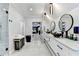 A luxurious bathroom featuring dual sinks, a frameless glass shower, designer lighting, and access to the Primary bedroom at 8525 Saint Marlo Fairway Way, Duluth, GA 30097