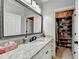 Well-lit bathroom featuring a granite countertop, large mirror, and organized closet space at 8525 Saint Marlo Fairway Way, Duluth, GA 30097