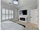 Cozy bedroom featuring a fireplace, mounted TV, and bright natural light at 8525 Saint Marlo Fairway Way, Duluth, GA 30097