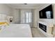 Well-lit bedroom features a comfy bed, modern fireplace, and large flat screen television at 8525 Saint Marlo Fairway Way, Duluth, GA 30097
