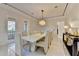 Elegant dining room with a long white table set, lit by a sparkling chandelier at 8525 Saint Marlo Fairway Way, Duluth, GA 30097