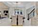 The dining room has a modern light fixture, a wooden table, and white chairs for gathering and entertaining at 8525 Saint Marlo Fairway Way, Duluth, GA 30097
