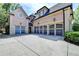 Brick home featuring a three-car garage with arched doors at 8525 Saint Marlo Fairway Way, Duluth, GA 30097