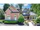 Elegant brick home with well-manicured landscaping, a circular driveway, and charming fountain feature at 8525 Saint Marlo Fairway Way, Duluth, GA 30097