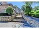 View of a stately home from the stone steps leading to the house and entry fountain at 8525 Saint Marlo Fairway Way, Duluth, GA 30097