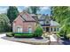 Charming two-story brick home with a fountain, manicured landscaping, and elegant curb appeal at 8525 Saint Marlo Fairway Way, Duluth, GA 30097