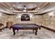 Basement game room highlighting a pool table, stone-like walls, coffered ceiling, and stylish lighting at 8525 Saint Marlo Fairway Way, Duluth, GA 30097