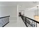 Long upstairs hallway with iron railing and bright, neutral colors, leads to the bedrooms at 8525 Saint Marlo Fairway Way, Duluth, GA 30097