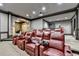 Home theater with comfortable red leather seating, a projector, and an arched entryway, perfect for entertaining guests at 8525 Saint Marlo Fairway Way, Duluth, GA 30097