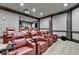 Spacious home theater featuring multiple red leather chairs, a projector, and stylish wall sconces for an enhanced viewing experience at 8525 Saint Marlo Fairway Way, Duluth, GA 30097