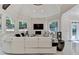 Bright living room features large sofa, stone fireplace, and walls of windows at 8525 Saint Marlo Fairway Way, Duluth, GA 30097