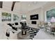 Bright living room featuring a stone fireplace and view to wooded surroundings at 8525 Saint Marlo Fairway Way, Duluth, GA 30097