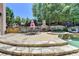 Charming outdoor patio with a stone fireplace, dining area, and a view of the pool, perfect for gatherings at 8525 Saint Marlo Fairway Way, Duluth, GA 30097