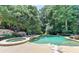 Inviting pool and spa area with lush landscaping, an outdoor fireplace, and comfortable seating at 8525 Saint Marlo Fairway Way, Duluth, GA 30097