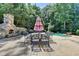 Inviting outdoor space with stone fireplace, dining table, and refreshing pool view at 8525 Saint Marlo Fairway Way, Duluth, GA 30097