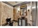 Stylish powder room with stone-like walls, dark fixtures, decorative lighting, and a modern vessel sink at 8525 Saint Marlo Fairway Way, Duluth, GA 30097